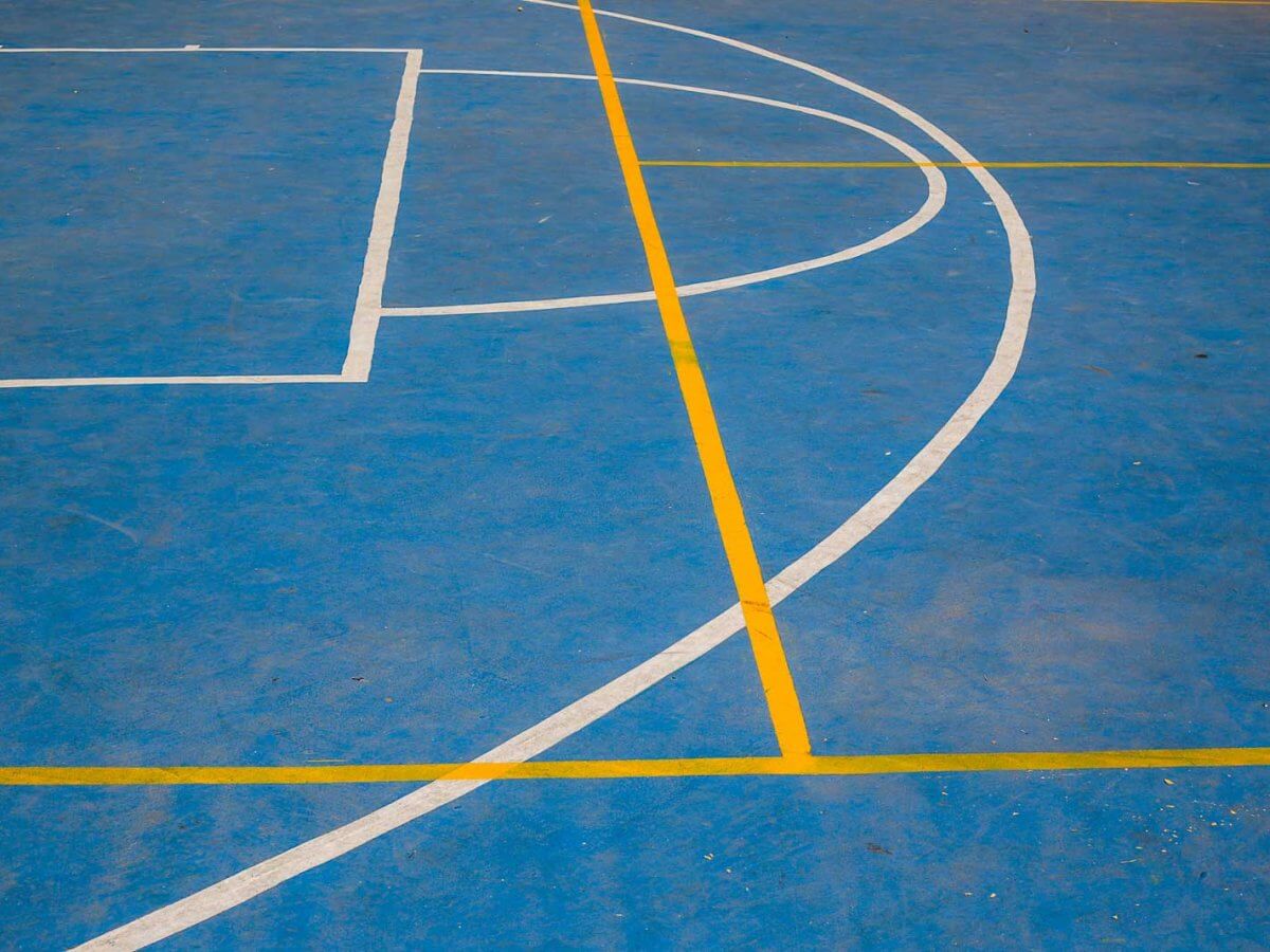 Una cancha deportiva azul con lineas blancas y amarillas