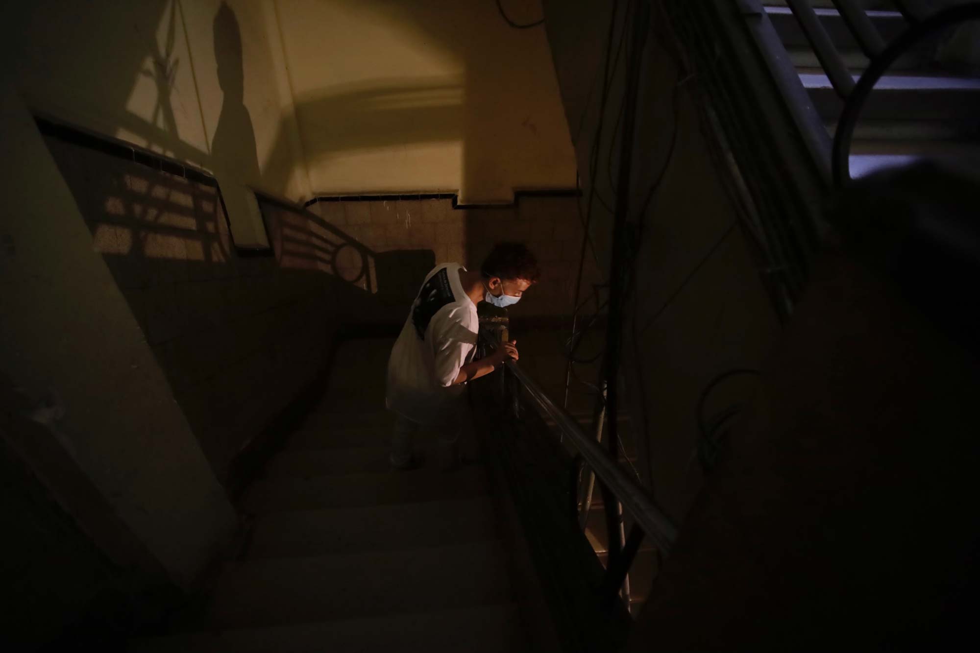 Un hombre se asoma dentro de un edificio a oscuras