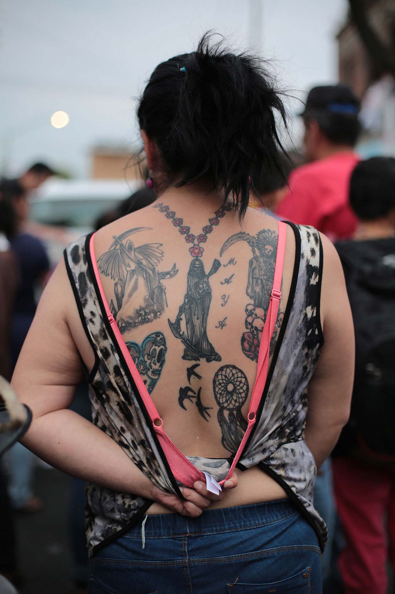 Una mujer muestra la espalda cubierta de tatuajes